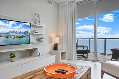 a living room with a tv and a large window at 15th-Floor Luxury 1BR at Lyfe Resort with Ocean View in Hollywood