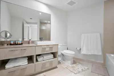 a bathroom with a sink and a toilet and a mirror at 15th-Floor Luxury 1BR at Lyfe Resort with Ocean View in Hollywood