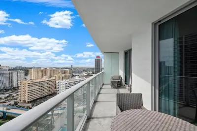 a balcony with chairs and a view of a city at 15th-Floor Luxury 1BR at Lyfe Resort with Ocean View in Hollywood