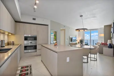 a kitchen and living room with a counter top and a kitchen and a dining area at 15th-Floor Luxury 1BR at Lyfe Resort with Ocean View in Hollywood