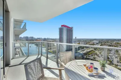 a balcony with a table and chairs and a view of a city at High Floor with Stunning Views Amazing Pools in Hollywood