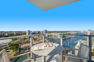 a balcony with a table and chairs and a view of the water at High Floor with Stunning Views Amazing Pools in Hollywood