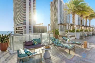 a balcony with chairs and palm trees on a building at High Floor with Stunning Views Amazing Pools in Hollywood