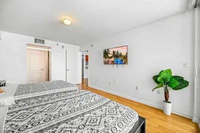a bedroom with two beds and a potted plant at Amazing cozy Condo in Brickell Miami in Miami