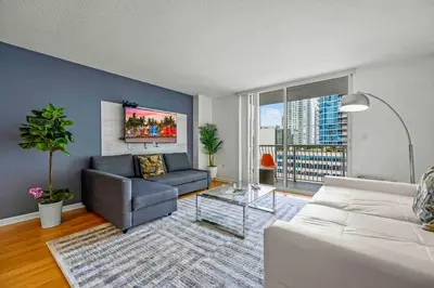 a living room with a white couch and a blue wall at Amazing cozy Condo in Brickell Miami in Miami