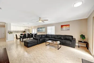 a living room with a black couch and a table at Walk to Hollywood Beach Luxury 4BR Villa in Hollywood