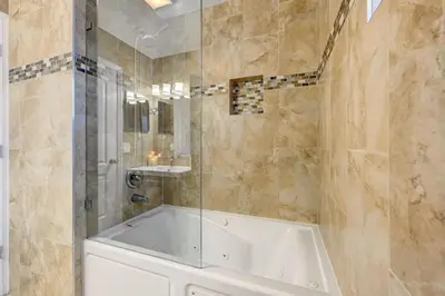 a bathroom with a tub and a glass shower at Great Location 5BR Heated Pool near Hollywood Beach in Hollywood