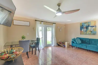 a living room with a blue couch and a table at Opa-locka Townhome, 15 Mi to Miami Beach! in Opa-locka