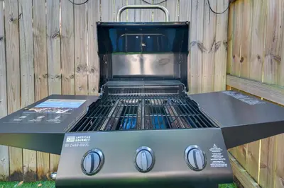 a gas grill sitting next to a wooden fence at Opa-locka Townhome, 15 Mi to Miami Beach! in Opa-locka