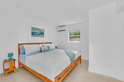 a white bedroom with a bed and a window at Quiet and secluded 4 bedroom home! in Fort Lauderdale