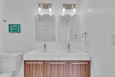 a bathroom with a sink and a toilet and a mirror at Quiet and secluded 4 bedroom home! in Fort Lauderdale