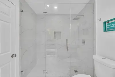 a shower with a glass door in a bathroom at Quiet and secluded 4 bedroom home! in Fort Lauderdale