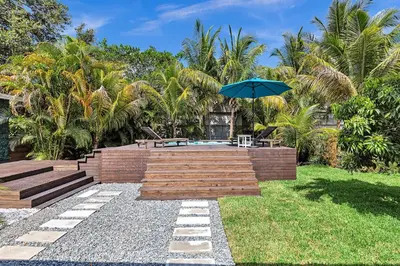 a patio with a table and an umbrella at Quiet and secluded 4 bedroom home! in Fort Lauderdale