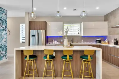 a kitchen with a island with four stools at Your Dream Home in Coral Ridge in Fort Lauderdale