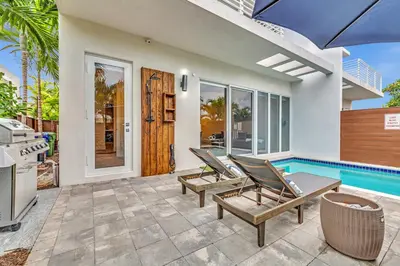 a patio with two chairs and a swimming pool at Your Dream Home in Coral Ridge in Fort Lauderdale