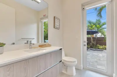 a bathroom with a toilet and a sink and a window at Your Dream Home in Coral Ridge in Fort Lauderdale