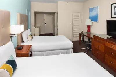 a hotel room with two beds and a television at Sherry Frontenac Oceanfront in Miami Beach