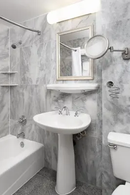 a bathroom with a sink and a mirror and a toilet at Sherry Frontenac Oceanfront in Miami Beach