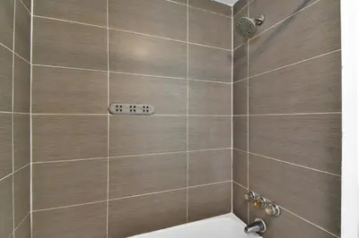 a bathroom with a shower with a clock on the wall at Seaheights Villa in Miami Beach