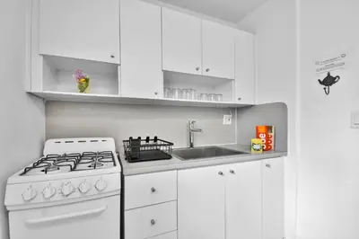 a white kitchen with a stove and a sink at Seaheights Villa in Miami Beach