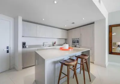 a kitchen with two bar stools and a counter at Beachfront Condo with Mesmerizing Views in Hollywood