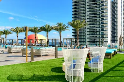a resort with a pool and chairs and palm trees at Beachfront Condo with Mesmerizing Views in Hollywood