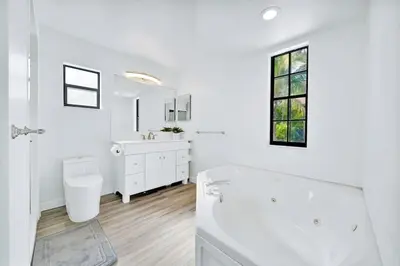 a white bathroom with a tub and a sink at Farmhouse Miami in Miami