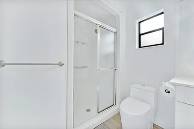 a white bathroom with a shower and a toilet at Farmhouse Miami in Miami
