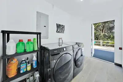 a laundry room with a washing machine with a sink at Farmhouse Miami in Miami