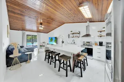 a kitchen with a large white table and wooden ceilings at Farmhouse Miami in Miami