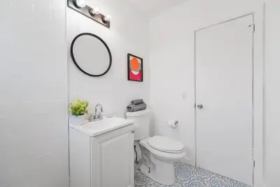 a bathroom with a toilet and a sink and a mirror at Beautiful Apt 2/2 Near The Beach in Miami