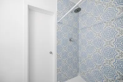 a bathroom with a shower with blue and white tiles at Beautiful Apt 2/2 Near The Beach in Miami