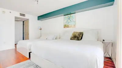 a white bedroom with a large white bed with a blue ceiling at Warm and Tailored 1BR w Pool Hot tub GYM Parking in Miami