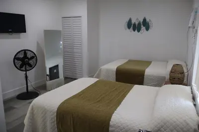 a hotel room with two beds and a fan at Rainbow Motel Miami in Miami