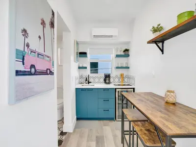 a kitchen with blue cabinets and a pink van at Rainbow Motel Miami in Miami