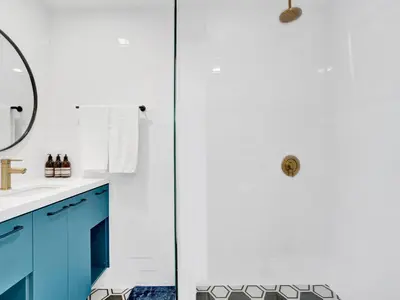 a bathroom with blue cabinets and a shower at Rainbow Motel Miami in Miami