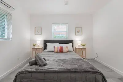 a large bed in a white room with two windows at Great Apartment 2 BR near the beach in Miami