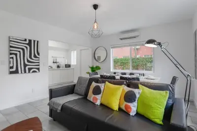 a living room with a black couch with yellow pillows at Great Apartment 2 BR near the beach in Miami