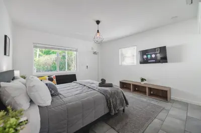 a white bedroom with a bed and a tv at Wonderful Studio Residence 15 min from the beach in Miami