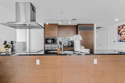 a kitchen with wooden cabinets and a counter top at Luxurious Condo at ICON with Views in Miami