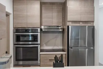 a kitchen with stainless steel appliances and wooden cabinets at Lauderdale Modern 1 Bedroom 1 Bathroom with Private Backyard in Fort Lauderdale