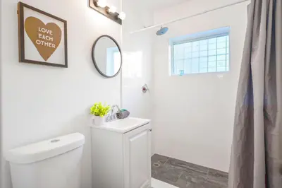 a white bathroom with a toilet and a mirror at Lovely Studio A Few Steps From The Beach in Miami