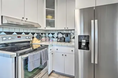 a kitchen with white cabinets and a stainless steel refrigerator at Gated Southern Miami Home 22 Mi to Downtown! in Miami