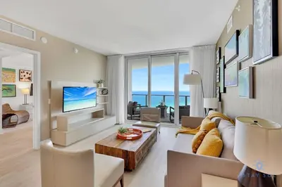 a living room with a couch and a tv at Ocean View Balcony Beachfront Resort Amazing Pools in Hollywood