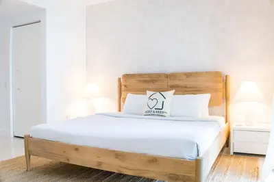 a bedroom with a bed with a wooden headboard at Brickell House Dreams - Luxury Stay and Amenities in Miami