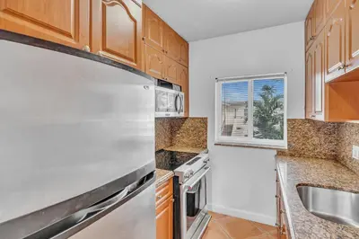 a kitchen with wooden cabinets and stainless steel appliances at Sea Angel in Hollywood Beach