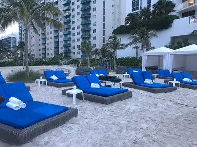 a group of blue lounge chairs on the beach at Beautiful penthouse condo with stunning views of both ocean and city in Hollywood