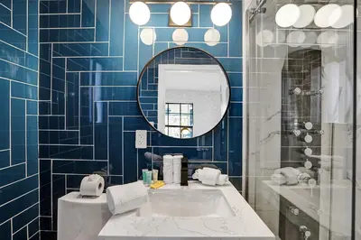a blue tiled bathroom with a sink and a mirror at Hollywood Apartments Host by BeeNomad in Hollywood