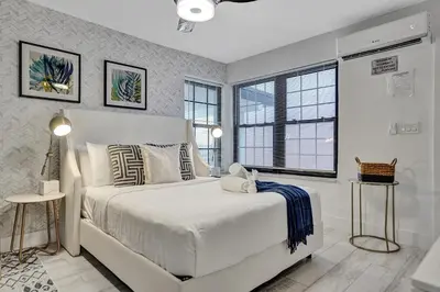 a bedroom with a white bed and two windows at Hollywood Apartments Host by BeeNomad in Hollywood