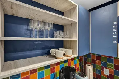 a kitchen with colorful tiles on a shelf with cups at Hollywood Apartments Host by BeeNomad in Hollywood